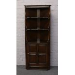 An Ercol corner cabinet with panelled door.