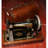 A Singer oak cased dome top sewing machine with original turn key.