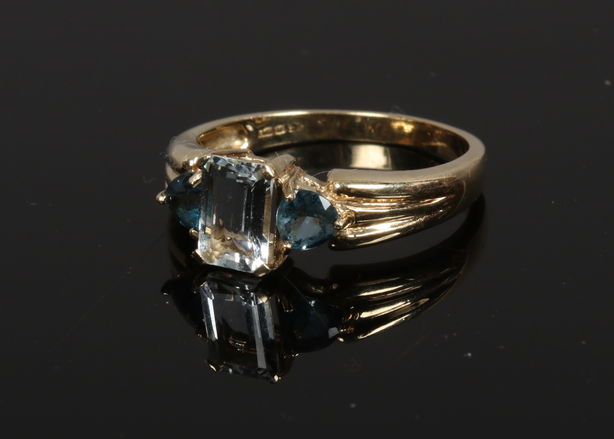 A 9ct gold aquamarine and topaz dress ring with reeded shoulders, size N.