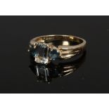 A 9ct gold aquamarine and topaz dress ring with reeded shoulders, size N.