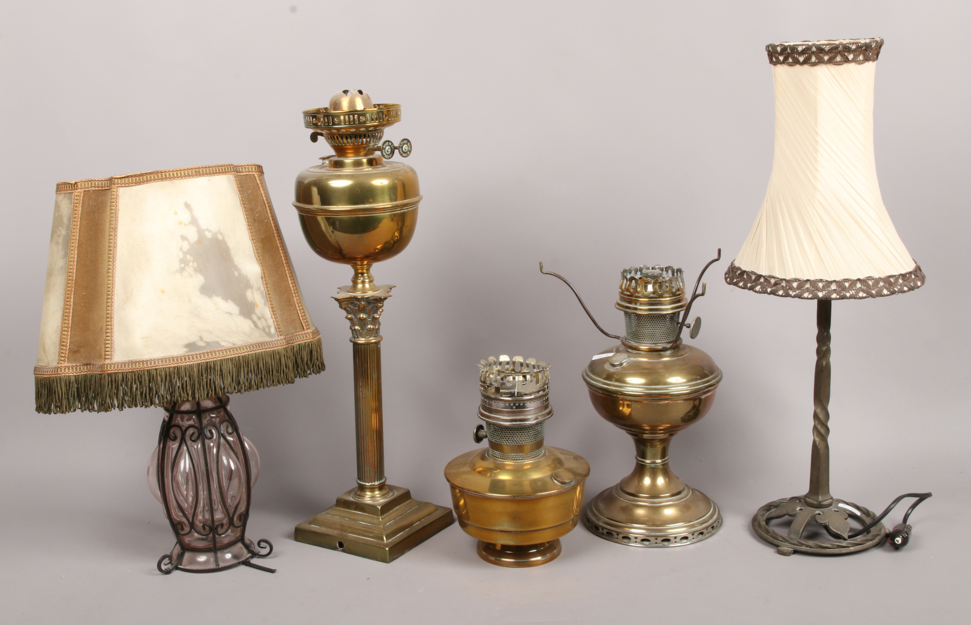 Three brass based oil lamps to include Corinthian column, along with a wrought iron and wire work