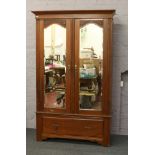 A carved mahogany mirror front wardrobe with drawer base.