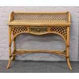 A rattan side table with single drawer.