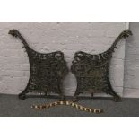 A pair of cast iron bench ends with floral decoration.
