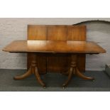 A twin pedestal yew wood dining table with three leaves.