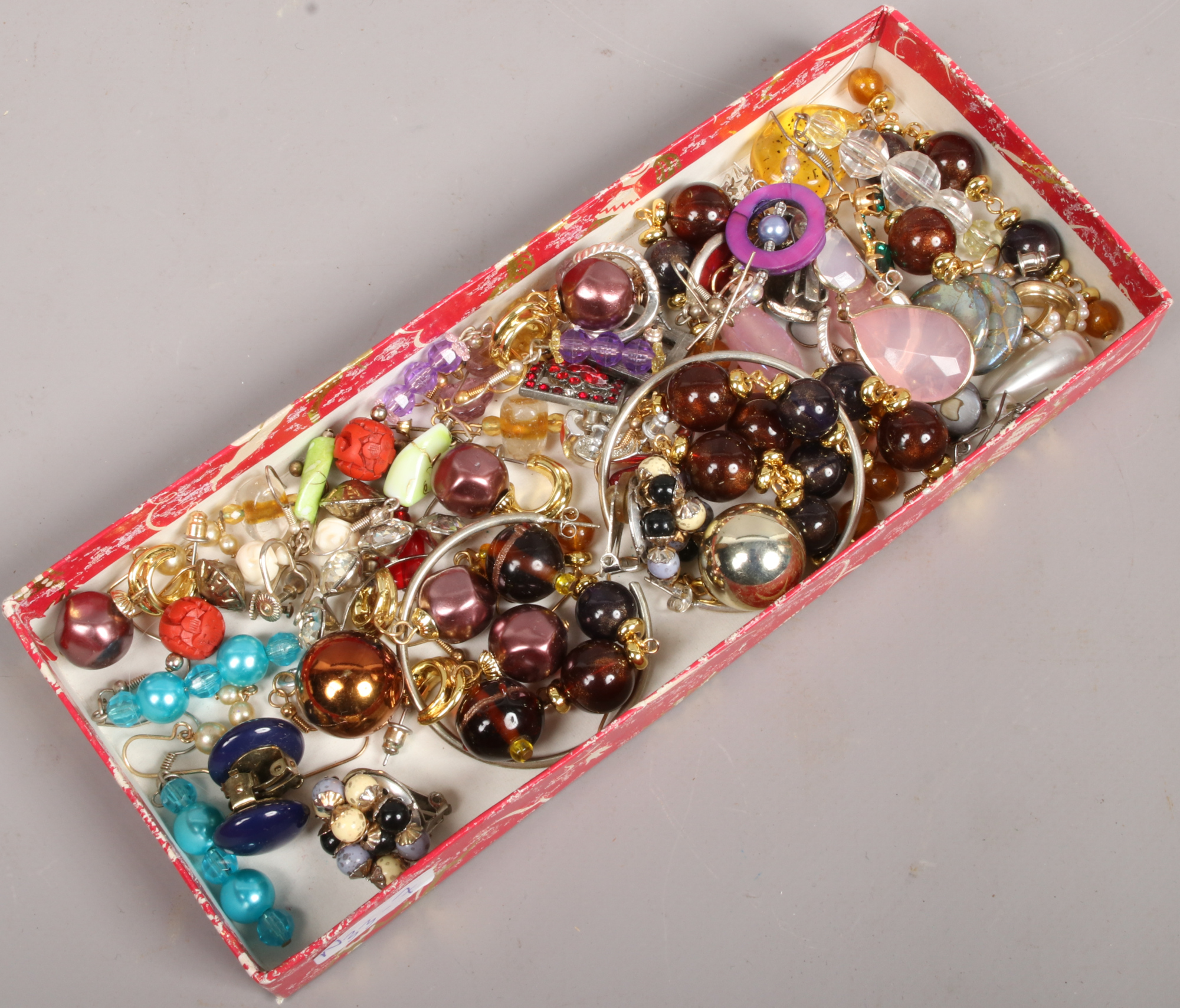 A tray of costume jewellery earrings including coloured glass and clip on examples.