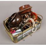 A tin of costume jewellery including necklaces, beads, bangles etc.
