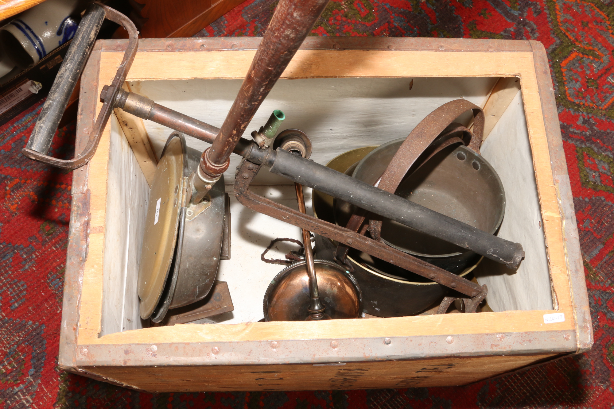 A wooden tea chest and contents to include bed pan, jam pans, advertising tins etc.