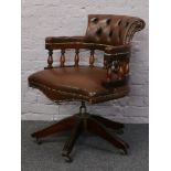 A mahogany and brown leather Captains swivel chair on castered base.