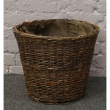 A wicker log basket with metal liner.
