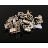 A silver charm bracelet to include love heart lock charm, horseshoe charm, rings etc weight 62
