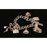 A silver charm bracelet to include silver ice skate charm, love heart lock, passport charm etc,