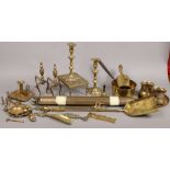 A collection of brassware to include Spitjack, candlesticks, firedogs, chamber stick and a bundle of