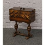 An oak cantilever sewing box raised on turned bulbous supports and contents including Sylko thread
