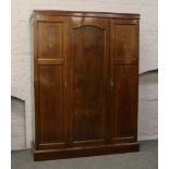 An Edwardian inlaid mahogany triple wardrobe with fitted interior.