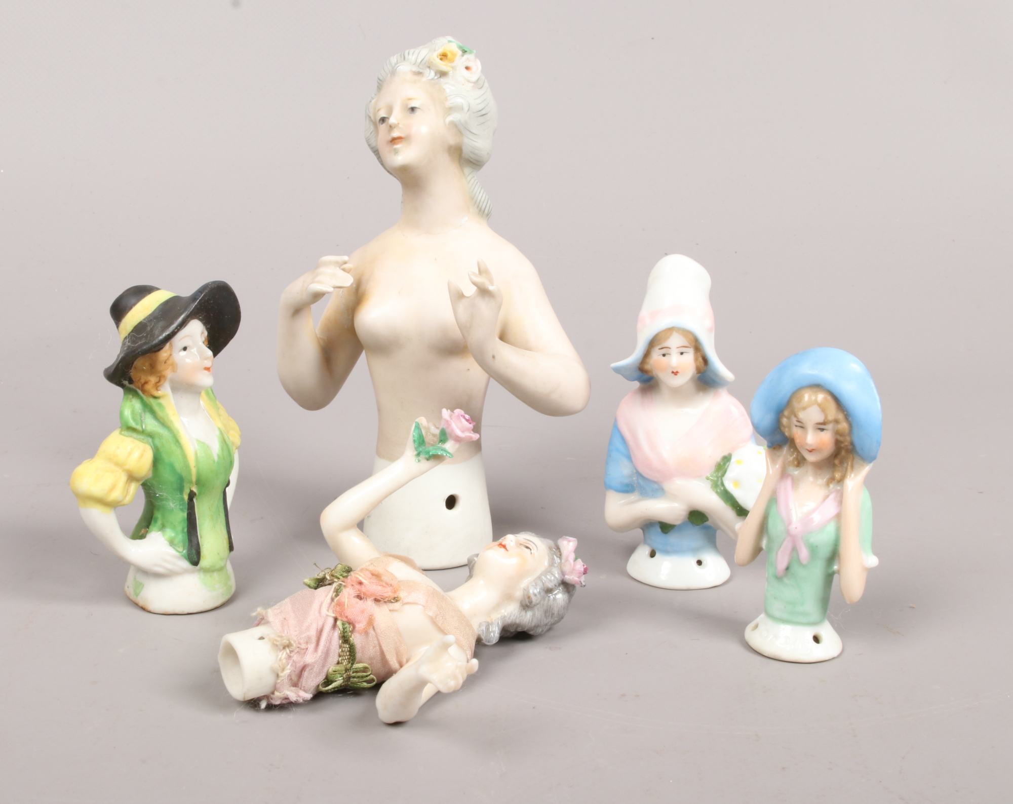 A tin of 5 continental china half dolls.