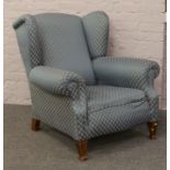 A Edwardian wing arm chair later re-upholstered in a modern fabric.