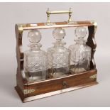 An oak cased tantulas with three cut glass decanters, with key.