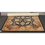 A blue ground wool rug decorated with stylised flowers, 170cm x 230cm.