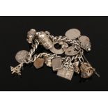 A silver charm bracelet to include love heart lock charm, bird cage charm etc, weight 58 grams.