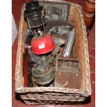 A wicker basket and contents of metalwares including Tilly lamp, bell , crank etc.