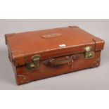 A good quality tan leather suitcase with reinforced corners, brass double lever locks with key and