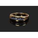 An 18ct gold channel set tanzanite ring, size N.