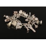 A silver charm bracelet to include love heart lock charm, animal charms, key charm etc, weight 62