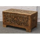 A camphor wood chest carved with dragons and raised on bracket supports.