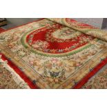 A very large red ground Chinese wool rug with floral design, approximately 3.6m x 2.78m.