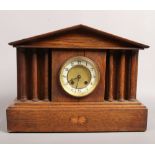 An 8 day oak mantle clock with column supports, chiming on a coiled gong with key.