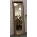 A large modern full length dressing mirror with deep basketware frame.