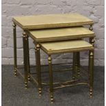 A nest of three onyx tables on gilt reeded supports.