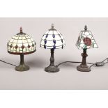 Three small Tiffany style leaded and coloured glass table lamps.