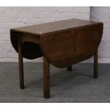 An oak drop leaf table on square cut legs.