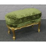 A French gilt stool with green floral upholstery.