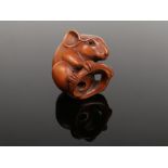 A Japanese carved boxwood netsuke. Delicately carved in the form of a rat and with glass inset eyes.