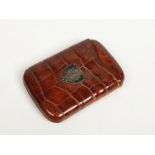 A crocodile skin cigar pouch with white metal shield shaped cartouche engraved with a cipher, 13.