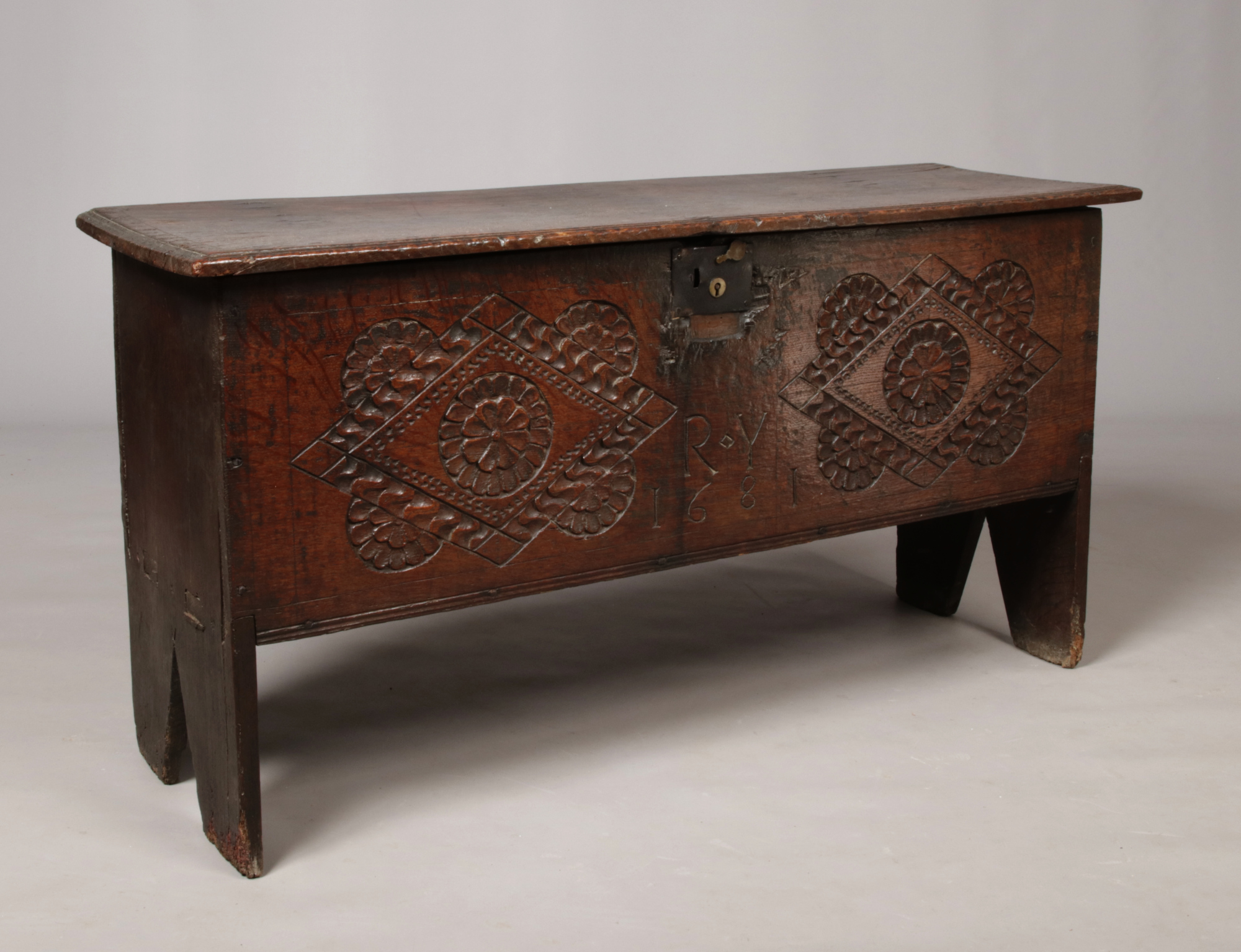A 17th century boarded oak coffer. With exposed tenons to the side planks, carved medallions to
