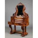 A Victorian mahogany Duchess serpentine dressing table. With shield shaped bevelled mirror on scroll