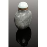 A Chinese carved grey hardstone snuff bottle with stopper. With carved and gilded character marks to