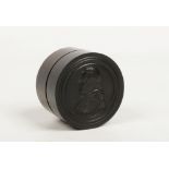 A hardwood cylindrical trinket box with threaded cover carved with a profile portrait of a pope,