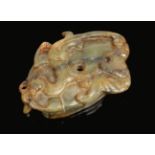 A 19th century Chinese mottled jade amulet, predominantly green with black and russet suffusions.