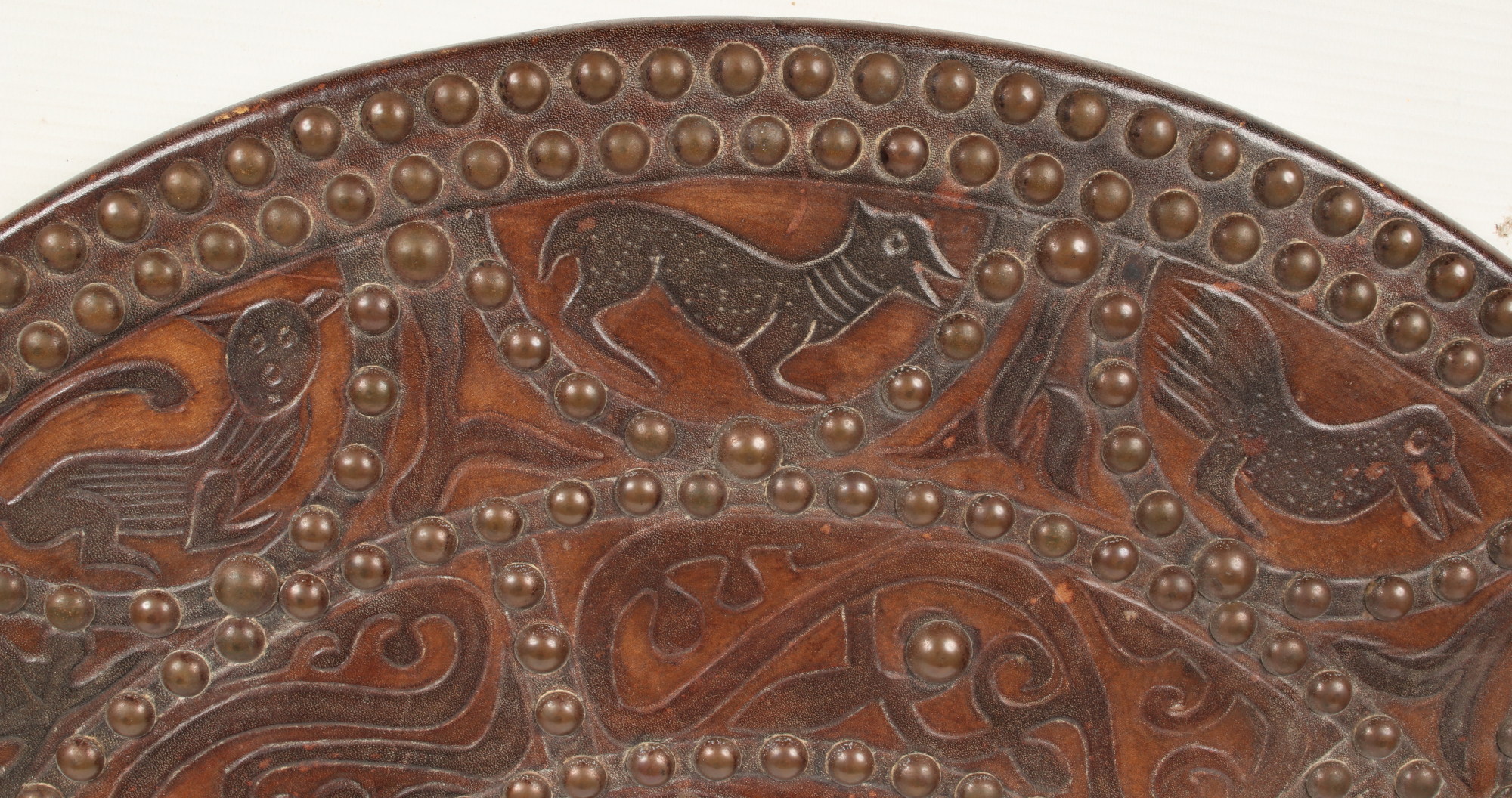 A decorative leather clad roundel shield adorned with brass studwork and tooled with animals and - Image 2 of 4