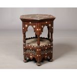 A middle eastern carved hexagonal two tier coffee table inlaid with mother of pearl. Probably