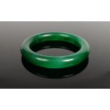 A Chinese 20th century carved and polished jade bangle of dark spinach colour, 7.75cm at the