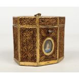 A Regency rolled paper canted rectangular tea caddy. Set to the front with a portrait miniature of a