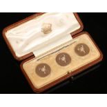 A cased set of three Victorian 9 carat gold novelty buttons each moulded in relief on a matt