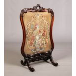 A large Victorian carved mahogany firescreen. With a needlework panel depicting a parrot and