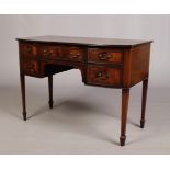 An Edwardian bow front mahogany desk. With strung inlay and raised on square tapering supports,